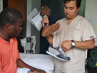 Disabled Haitan man with prosthetist Kamil Leman